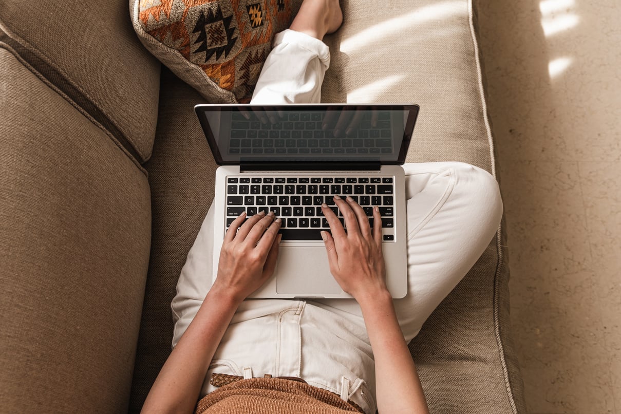 Person Using a Laptop While Sitting on the Couch