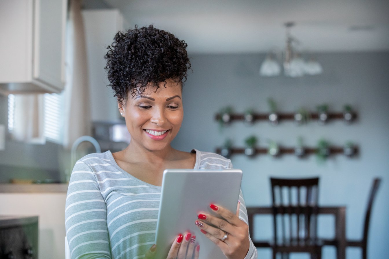 Woman uses digital tablet to call doctor for telehealth appointment